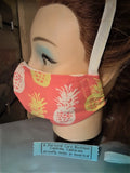 A Personal Care Boutique Face Mask cotton handsewn in California whit and yellow pineapples on orange